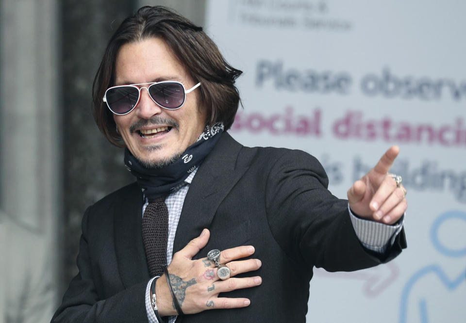 Actor Johnny Depp gestures as he arrives at the High Court to give evidence in his libel case, in London, Wednesday July 15, 2020. Depp is suing News Group Newspapers, publisher of The Sun, and the paper’s executive editor, Dan Wootton, over an April 2018 article that called him a “wife-beater.” The Sun’s defense relies on a total of 14 allegations by Amber Heard of Depp’s violence. He strongly denies all of them. ( Jonathan Brady/PA via AP)