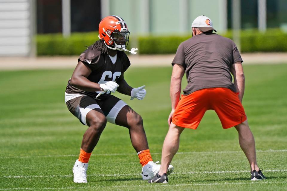 Cleveland Browns tackle James Hudson III, left, runs a drill during an NFL football rookie minicamp at the team's training camp facility, Friday, May 14, 2021, in Berea, Ohio. (AP Photo/Tony Dejak)