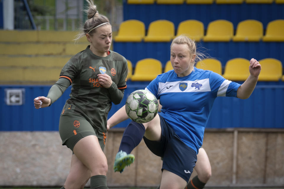 Players of a women's football team from Mariupol, right, and Shakhtar challenge for the ball during Ukrainian championship match in Kyiv, Ukraine, Tuesday, April 18, 2023. After their city was devastated and captured by Russian forces, the team from Mariupol rose from the ashes when they gathered a new team in Kyiv. They continue to play to remind everyone that despite the occupation that will soon hit one year, Mariupol remains a Ukrainian city. (AP Photo/Efrem Lukatsky)