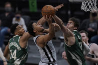 San Antonio Spurs forward Keldon Johnson, center, shoots against Milwaukee Bucks forward Giannis Antetokounmpo (34) and Milwaukee Bucks center Brook Lopez (11) during the second half of an NBA basketball game in San Antonio, Monday, May 10, 2021. (AP Photo/Eric Gay)