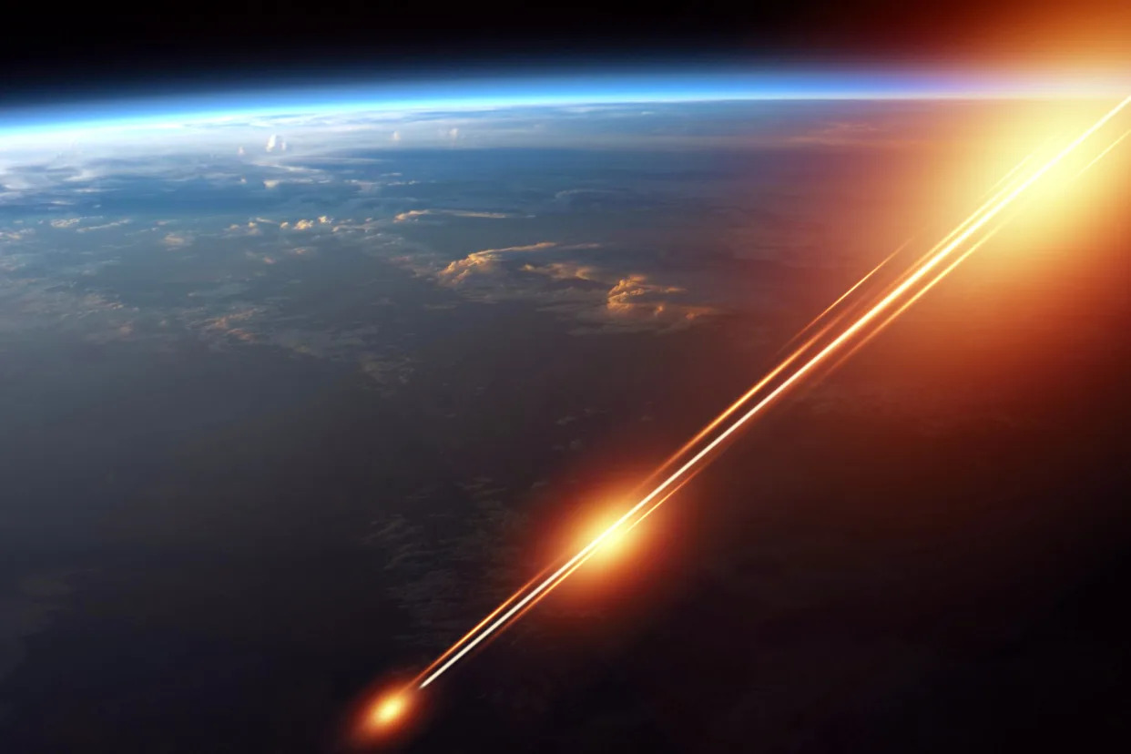 A weapon in space shoots a laser against the background of the earth