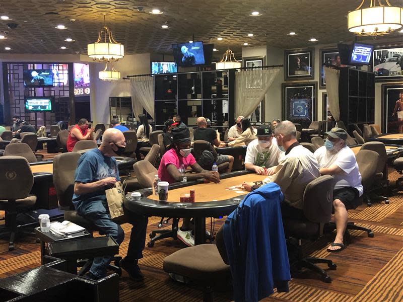 In the poker room at Caesars Palace, the day Nevada Gov. Steve Sisolak's mask order went into effect, everyone packed the tables played with shielded faces.