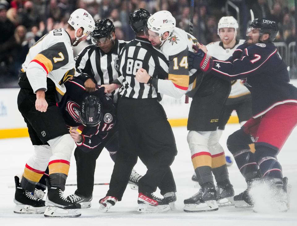 Sun., Mar. 13, 2022; Columbus, Ohio, USA; A referee holds back Vegas Golden Knights defenseman Nicolas Hague (14) as he fights with Columbus Blue Jackets center Max Domi (16) during the first period of a NHL game between the Columbus Blue Jackets and the Vegas Golden Knights at Nationwide Arena. 