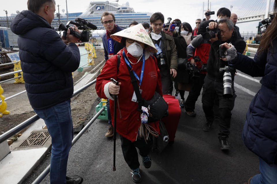 An unidentified passenger is surrounded by the media after she disembarked from the quarantined Diamond Princess cruise ship on Feb. 19, 2020, in Yokohama, Japan.