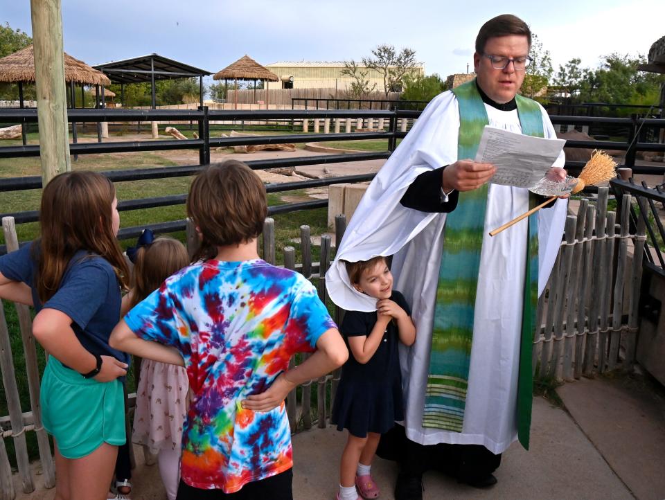 Grace Romanik, 4, hides momentarily in the sleeve of her father’s garment as he reads a prayer during St. Francis at the Zoo Wednesday Oct. 4. The Episcopal Church of the Heavenly Rest invited the public to its annual blessing of the animals at the Abilene Zoo, one of many seasonal community events held at the park.
