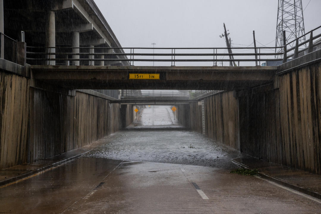 Rainwater floods a highway underpass.