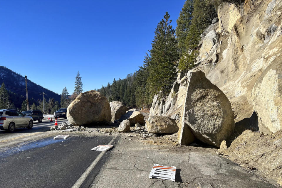 In this photo provided by Caltrans District 3, several large boulders lie in the street that fell onto Highway 50 just east of Kyburz during a storm in El Dorado National Park, Calif., Sunday, Jan. 1, 2023. Fortunately, no vehicles were hit. (Caltrans District 3 via AP)