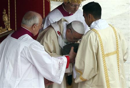 Pope Francis kisses the relics of the Apostle Peter on the altar during a mass at St. Peter's Square at the Vatican November 24, 2013. REUTERS/Stefano Rellandini