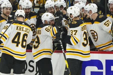 May 16, 2019; Raleigh, NC, USA; Boston Bruins left wing Brad Marchand (63) celebrates with center Patrice Bergeron (37) after scoring a third period empty net goal against the Carolina Hurricanes in game four of the Eastern Conference Final of the 2019 Stanley Cup Playoffs at PNC Arena. The Boston Bruins defeated the Carolina Hurricanes 4-0. Mandatory Credit: James Guillory-USA TODAY Sports