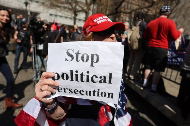 A Trump supporter holds a sign reading 
