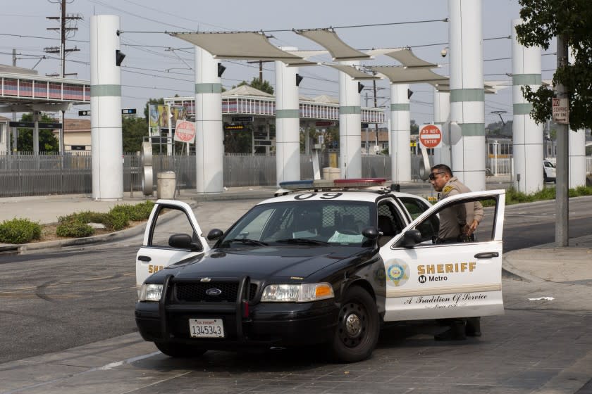 COMPTON , CA - SEPTEMBER 13: A sheriff's deputiy maintain a perimeter near the Metro Blue Line Station at Willowbrook Avenue and Palmer Street on Sunday, Sept. 13, 2020 in Compton , CA. Two Los Angeles County sheriff's deputies were in critical condition with multiple gunshot wounds Saturday evening after a gunman approached their patrol car and fired into the vehicle. (Gabriella Angotti-Jones / Los Angeles Times)