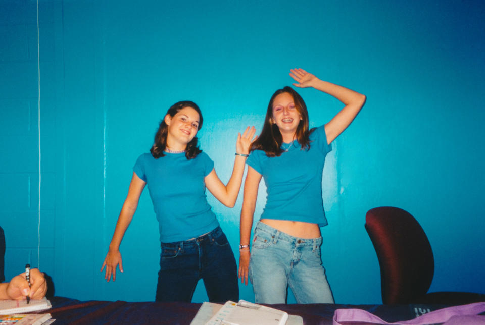 Two young girls taking a photo together in matching shirts