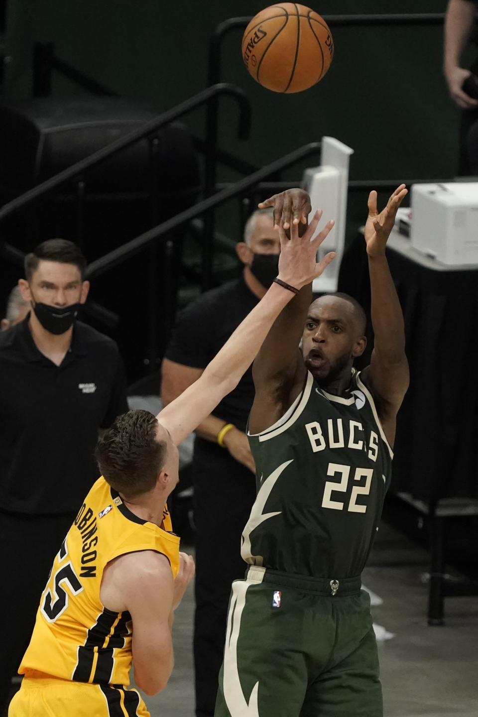 Milwaukee Bucks' Khris Middleton makes a basket over Miami Heat's Duncan Robinson in the final seconds of overtime of Game 1 of their NBA basketball first-round playoff seriesSaturday, May 22, 2021, in Milwaukee. The Bucks won 109-107 to take a 1-0 lead in the series. (AP Photo/Morry Gash)