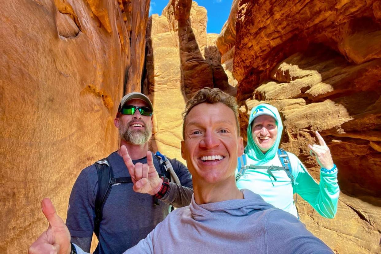 Three smiling people make hand gestures at Fiery Furnace.