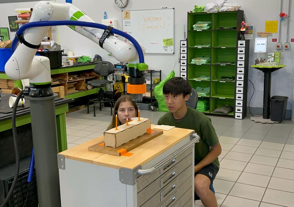 Fab Lab volunteers Viktoria and Michael program the RND Automation robotic arm to sharpen a pencil. Plans are underway to provide students with opportunities to work on real world automation projects.
