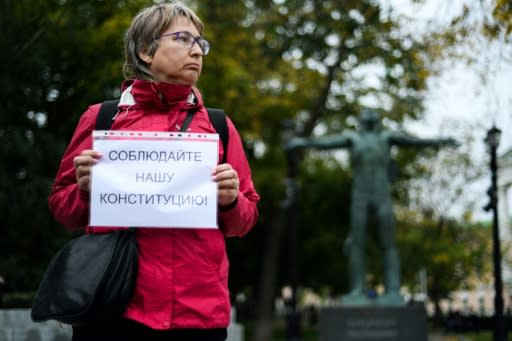 A Russian opposition activist holds a placard reading 'Respect our Constitution' during the one-persons protests in central Moscow