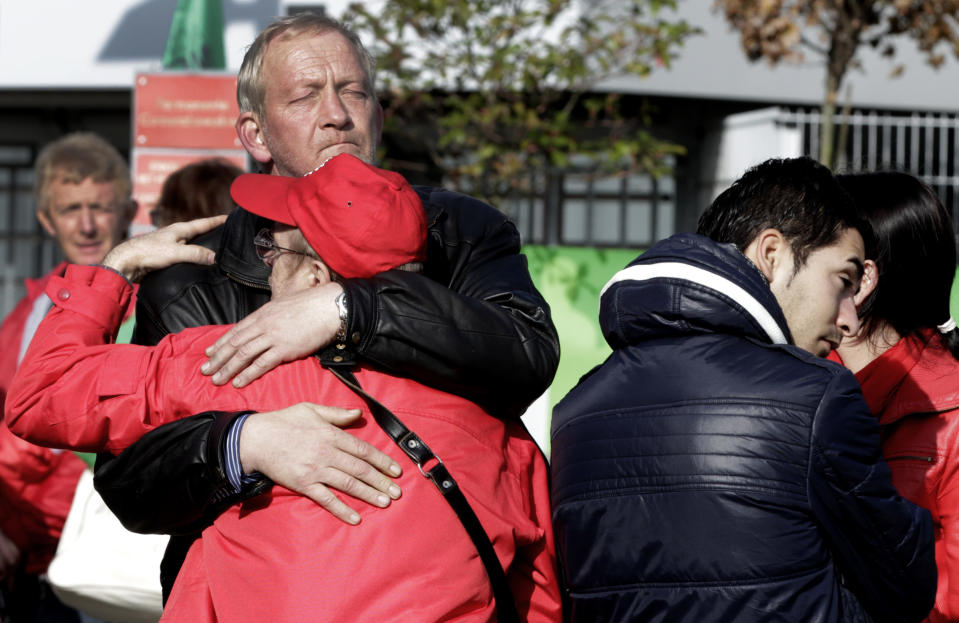 Workers embrace as they react to job loss news in front of the Ford factory in Genk, Belgium on Wednesday, Oct. 24, 2012. On Wednesday the Ford Motor Co. announced it would close one of its main factories in eastern Belgium by the end of 2014 in a move that will result in 4,500 direct job losses and 5,000 more among subcontractors. (AP Photo/Virginia Mayo)