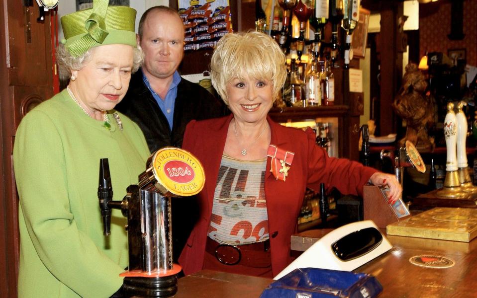 The Queen visiting the set of the Queen Vic pub with Barbara Windsor (Peggy Mitchell) and Steve McFadden who played her son Phil, 2001 - Anwar Hussein/Getty