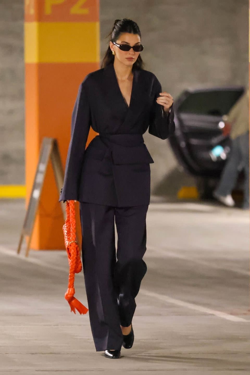 kendall jenner pairs navy suit with an orange bag