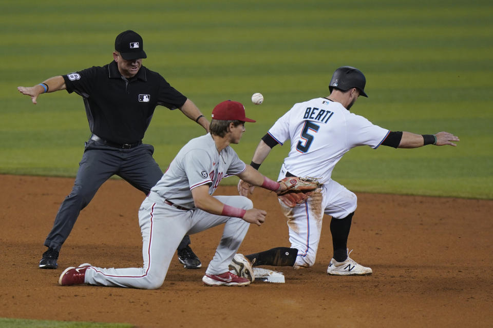 Second base umpire Mike Muchlinski, left, signals safe as Philadelphia Phillies second baseman Nick Maton attempts to tag Miami Marlins' Jon Berti (5) as Berti steals second during the third inning of a baseball game, Tuesday, May 25, 2021, in Miami. (AP Photo/Wilfredo Lee)