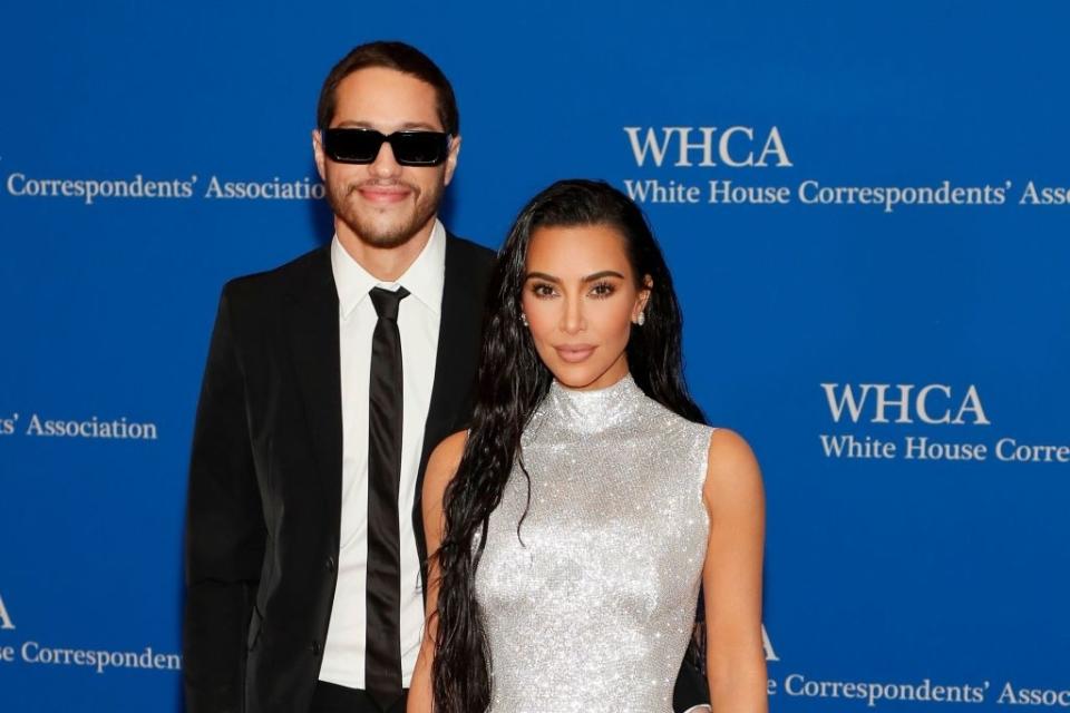 Pete and Kim posing at the White House Correspondents' Association event, one in a sparkling sleeveless dress and the other in a suit with sunglasses