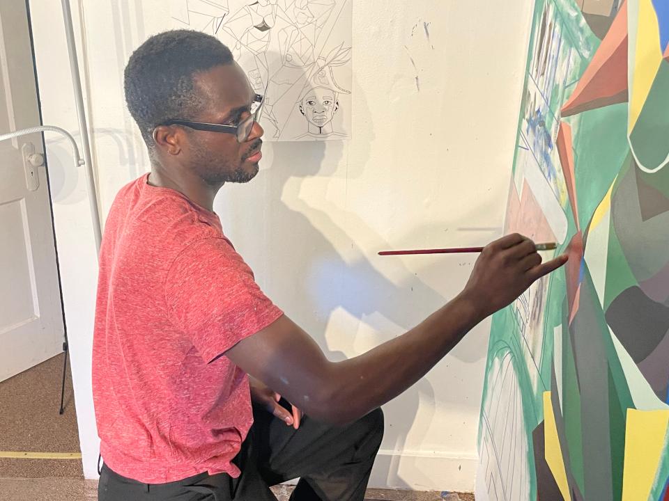 Norwich artist Samson Tonton working on a new piece that will debut at a show on Friday, as part of Haitian Heritage Month.