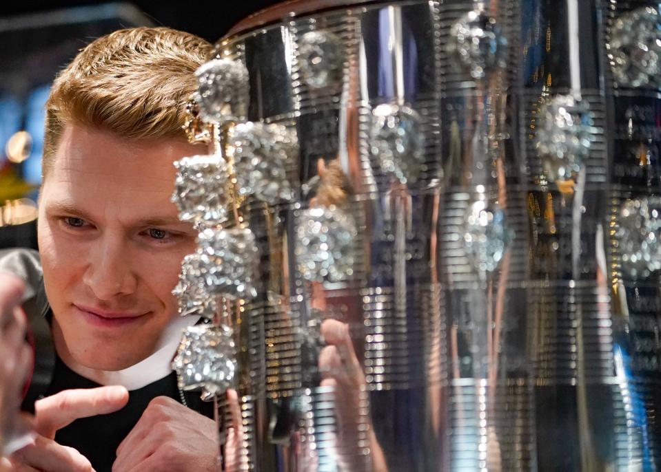 Two thousand twenty three Indy 500 winner Josef Newgarden is photographed with his likeness during an unveiling ceremony for the latest addition to the Borg-Warner Trophy on Friday, Dec. 15, 2023, at the Stutz Museum in Indianapolis.