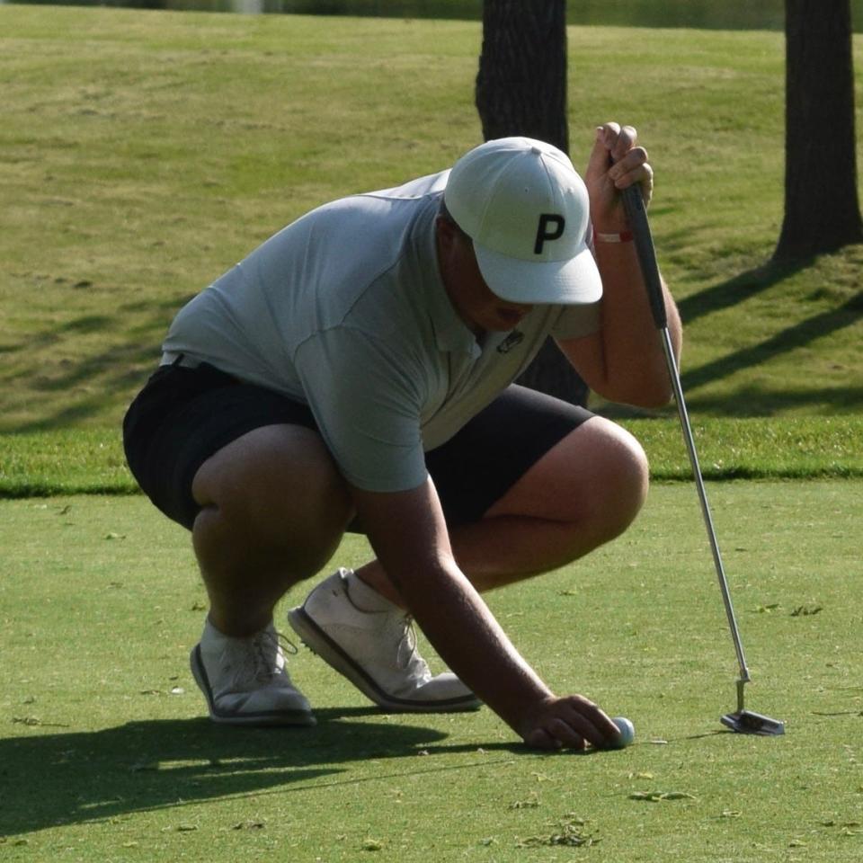 Monrovia junior Titus Boswell sets down his ball on the putting green during the Bulldogs' dual match against Edgewood. (Seth Tow/Herald-Times)