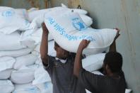 Workers unload bags of food from a UN's World Food Programme ship docked in Aden on July 21, 2015