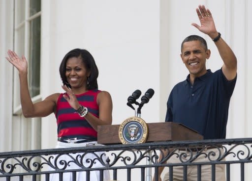 US President Barack Obama and First Lady Michelle Obama at an Independence Day celebration in Washington, DC on July 4. First Lady Michelle Obama will head the US delegation in London to watch the Olympic cauldron lit by a mystery personality in a £27 million extravaganza