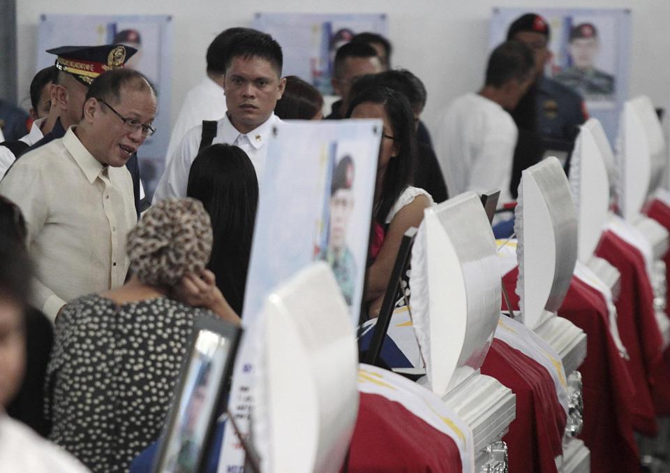Philippine President Benigno Aquino talks with relatives of the slain members of the Special Action Force (SAF) who were killed in Sunday's clash with Muslim rebels, during a service inside a police headquarters in Taguig city, south of Manila January 30, 2015. Aquino urged legislators on Wednesday not to abandon a plan for autonomy for Muslims to end a decades-old insurgency after the clash in which dozens of people were killed, saying doing so would dash hopes for peace. A top official described the clash on Sunday, which shattered a three-year ceasefire, as a misencounter during a bid to arrest two militants who had taken refuge with Moro Islamic Liberation Front (MILF) fighters. REUTERS/Romeo Ranoco 