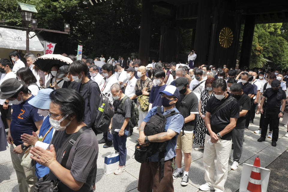 Visitors observe a minute of silence for paying respects to the war dead at Yasukuni Shrine Monday, Aug. 15, 2022, in Tokyo. Japan marked the 77th anniversary of its World War II defeat Monday. (AP Photo/Eugene Hoshiko)