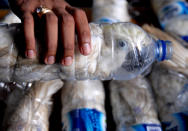 <p>A policeman holds a water bottle with a yellow-crested cockatoo put inside for illegal trade, at the customs office of Tanjung Perak port in Surabaya, East Java province, Indonesia, May 4, 2015 in this picture taken by Antara Foto. Police arrested one man traveling by ship from Makassar, Sulawesi with 22 of the endangered cockatoos held inside water bottles. (Photo: Antara Foto/Risyal Hidayat/Reuters) </p>