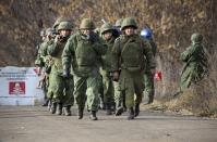 FILE - In this Nov. 9, 2019, file photo, Russia-backed separatist rebels' unit walk to take their position at the new line of contact outside Petrivske, Ukraine. Tensions are rising over the conflict in eastern Ukraine, with growing violations of a cease-fire and a massive Russian military buildup near its border with the region. (AP Photo/Alexei Alexandrov, File)