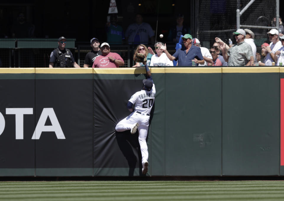 The home run ball hit by Colorado Rockies' Brendan Rodgers bounces among fans in the stands with Seattle Mariners center fielder Taylor Trammell leaping during the second inning of a baseball game, Wednesday, June 23, 2021, in Seattle. (AP Photo/John Froschauer)