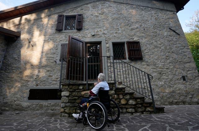 The retired American soldier in front of the house where he first met the children