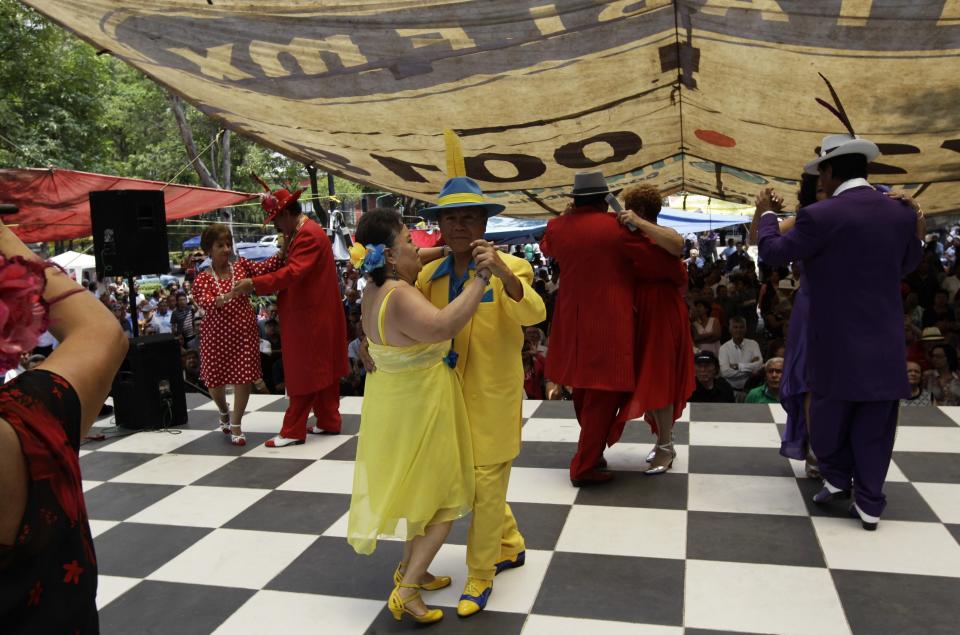 Men dressed in "Pachuco" style dance with their female partners dressed as "Rumberas" on a stage in Mexico City