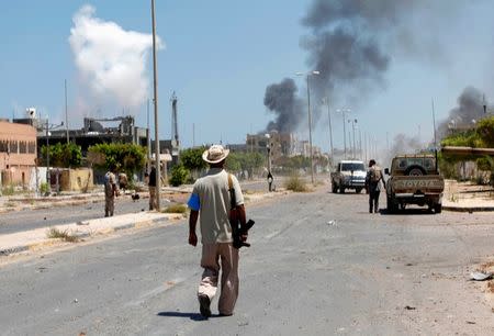 Smoke rises during a battle between Libyan forces allied with the U.N.-backed government and Islamic State fighters in neighborhood Number Two in Sirte, Libya August 16, 2016. REUTERS/Ismail Zitouny