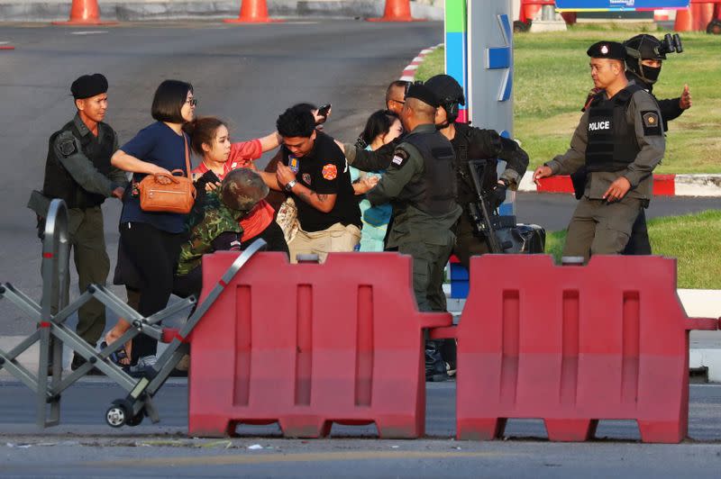 Thai security forces evacuate people who were stranded inside the Terminal 21 shopping mall following a gun battle, to try to stop a soldier on a rampage after a mass shooting, Nakhon Ratchasima