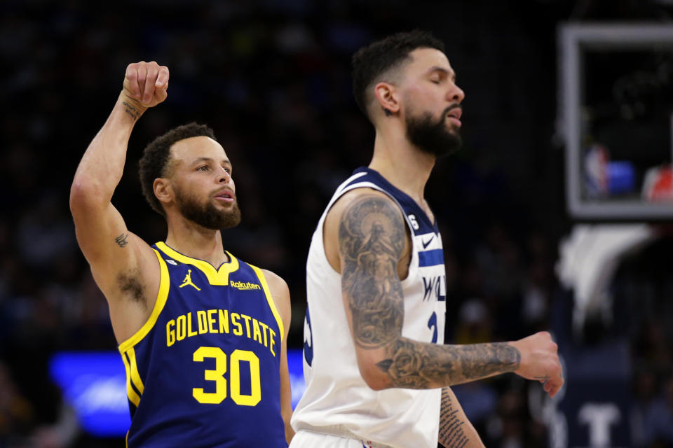 Golden State Warriors guard Stephen Curry (30) watches his 3-point basket, next to Minnesota Timberwolves guard Austin Rivers during the fourth quarter of an NBA basketball game Sunday, Nov. 27, 2022, in Minneapolis. (AP Photo/Andy Clayton-King)