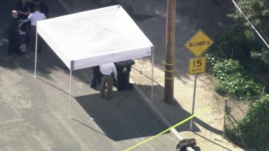A homicide tent covers a trash can where a body was found in Sunland on April 16, 2024. (KTLA)