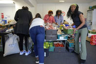 Volunteers prepare food before the Community Food Hub opens in Hackney, London, Thursday, June 13, 2024. Since calling a general election, British Prime Minister Rishi Sunak has been at pains to repeat a key message on the campaign trail: The economy is turning a corner, inflation is down, and things are looking up. That’s not the reality for millions across the U.K. still feeling the squeeze from high food, energy and housing prices. (AP Photo/Kin Cheung)