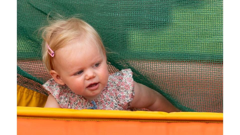 A baby playing in a bouncy castle