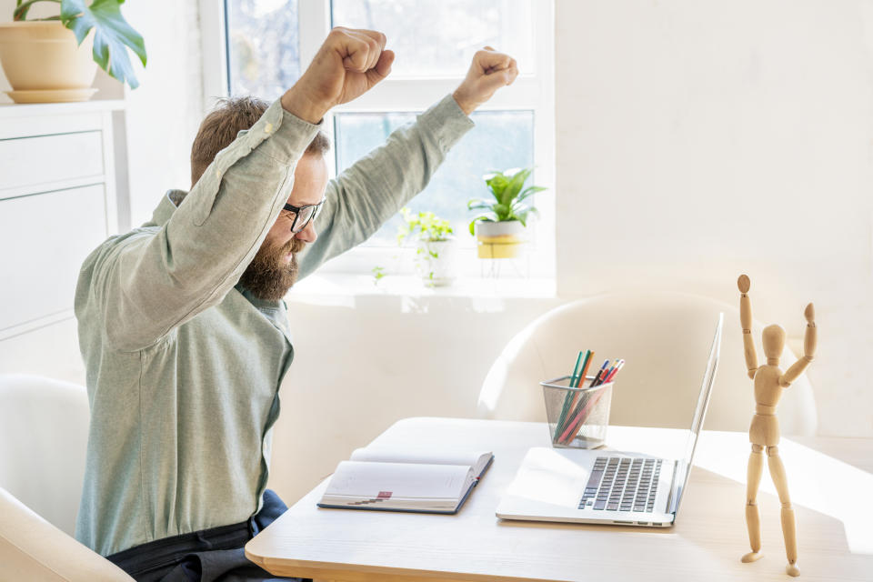 Stock investor looking at a computer screen celebrating