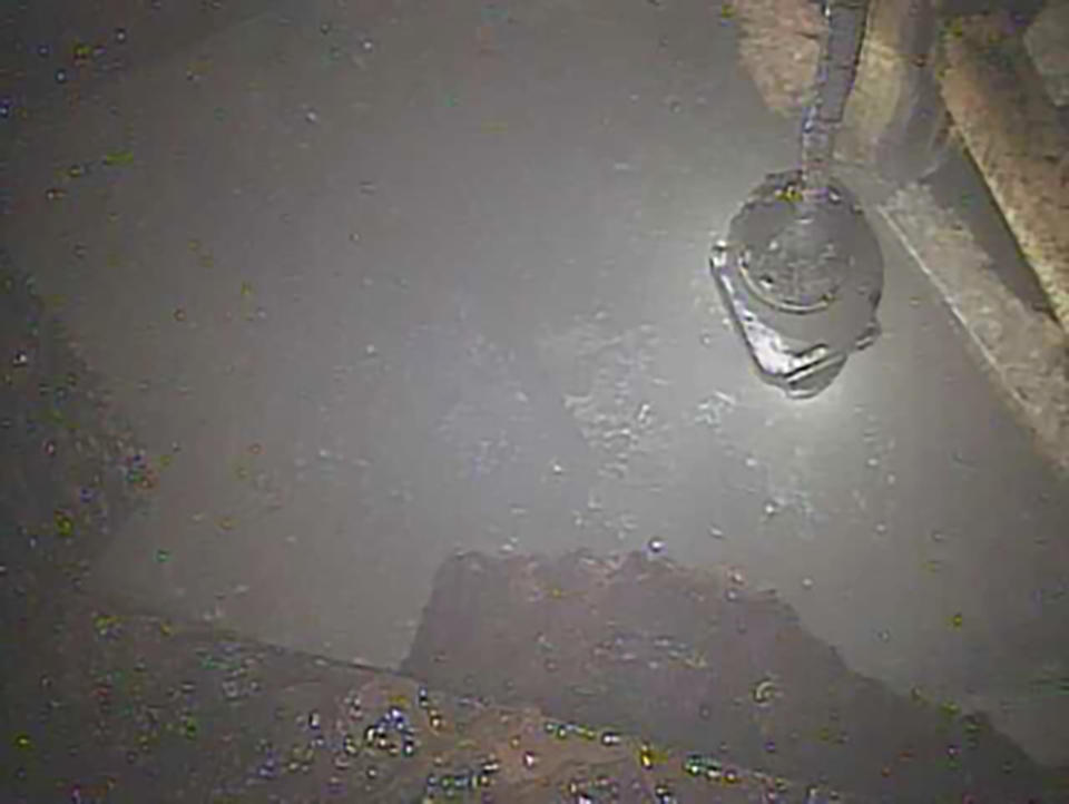 This image released by Tokyo Electric Power Co. (TEPCO), shows a telescopic robot as it examines and captures the image of parts of melted fuel inside of the primary containment vessel of Unit 2 reactor at the Fukushima Dai-ichi plant in Okuma, northeast Japan. Japan’s economy and industry ministry unveiled a draft revision Monday, Dec. 2, 2019, to its decades-long roadmap to clean up the radioactive mess at the Fukushima nuclear power plant, which was wrecked by a massive earthquake and tsunami in 2011. (Tokyo Electric Power Co. via AP)