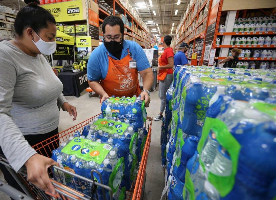 Home Depot supervisor Arnaldo Gonzalez loaded water bottles into Elena Arvalo’s shopping cart as shoppers prepared for tropical storm Elsa in July 2021.