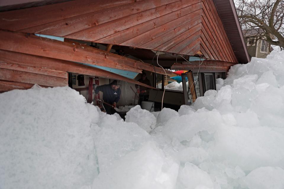 Wade Sammons works to clear ice after an Ice shove pushed ashore on the west shore of Lake Winnebago damaging his parents' summer home on Friday, March 25, 2022, in Oshkosh, Wis.