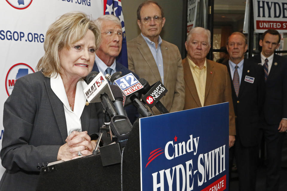 U.S. Sen. Cindy Hyde-Smith, R-Miss., left, thanks fellow Republican U.S. Sen. Roger Wicker, of Mississippi, second from left, Lt. Gov.-elect Delbert Hosemann, center, and former Mississippi Republican Gov. Haley Barbour, for supporting her bid for re-election, Friday, Jan. 3, 2020, at state GOP headquarters in Jackson, Miss. Hyde-Smith filed papers to run at party headquarters, with many Republican elected officials in attendance. She is expected to campaign by emphasizing her loyalty to President Donald Trump. (AP Photo/Rogelio V. Solis)