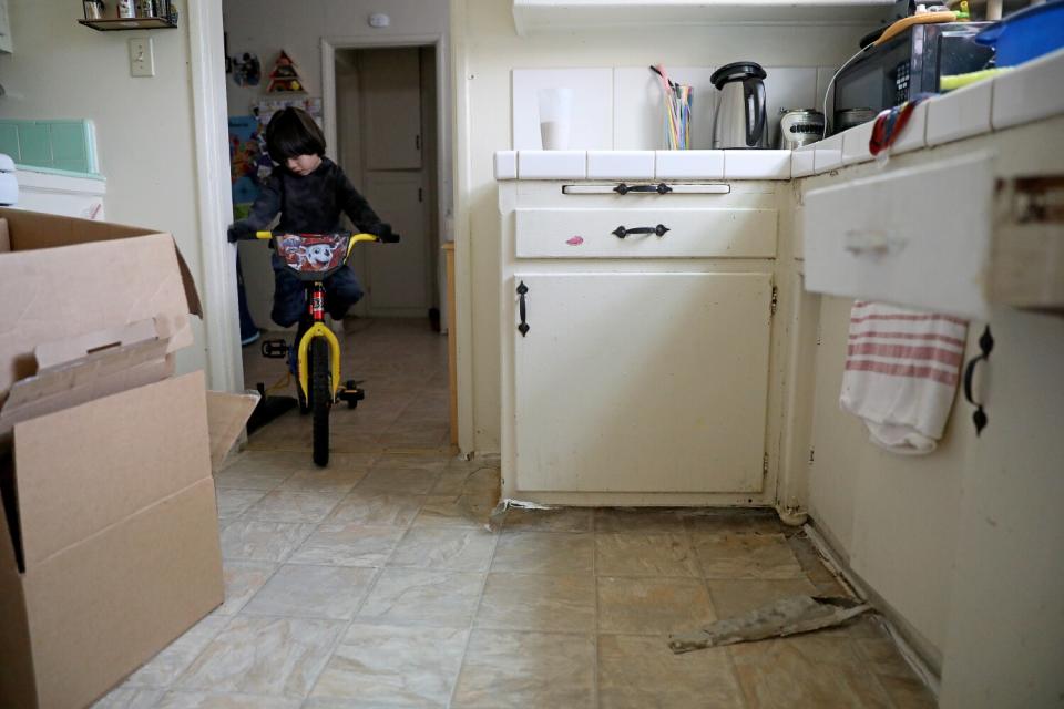 Liam Ponce plays on a cracked kitchen floor at the Chesapeake Apartments.