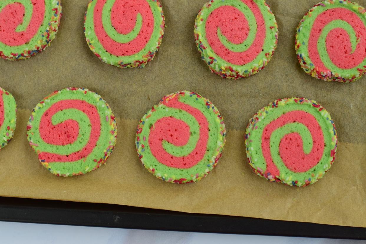 Red green pinwheel Christmas cookies on baking sheet